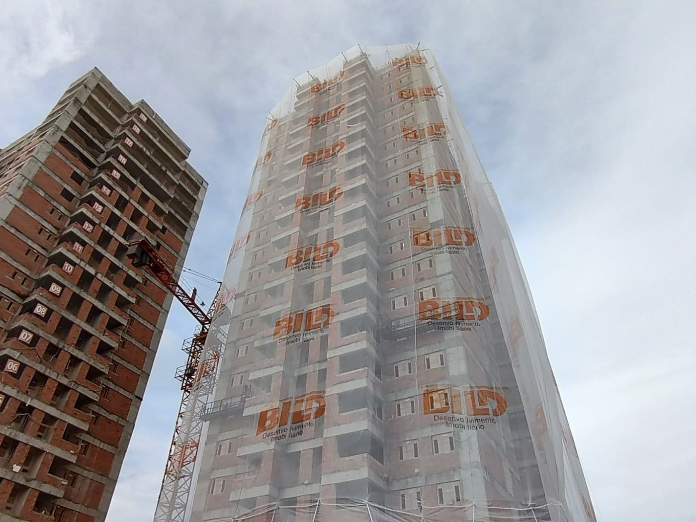 Tela de fachada com a marca da construtora
